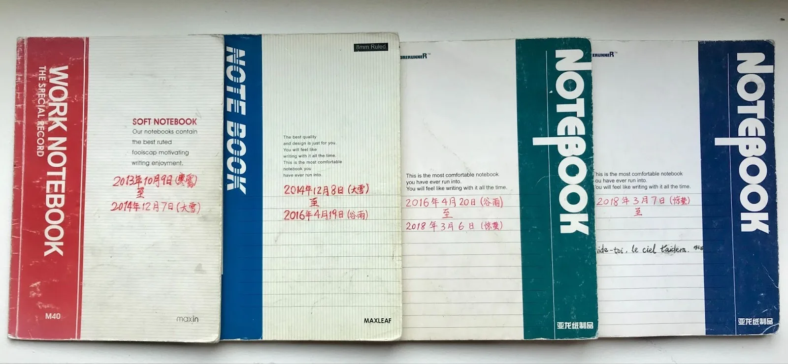 A row of weather observation notebooks filled with handwritten entries.